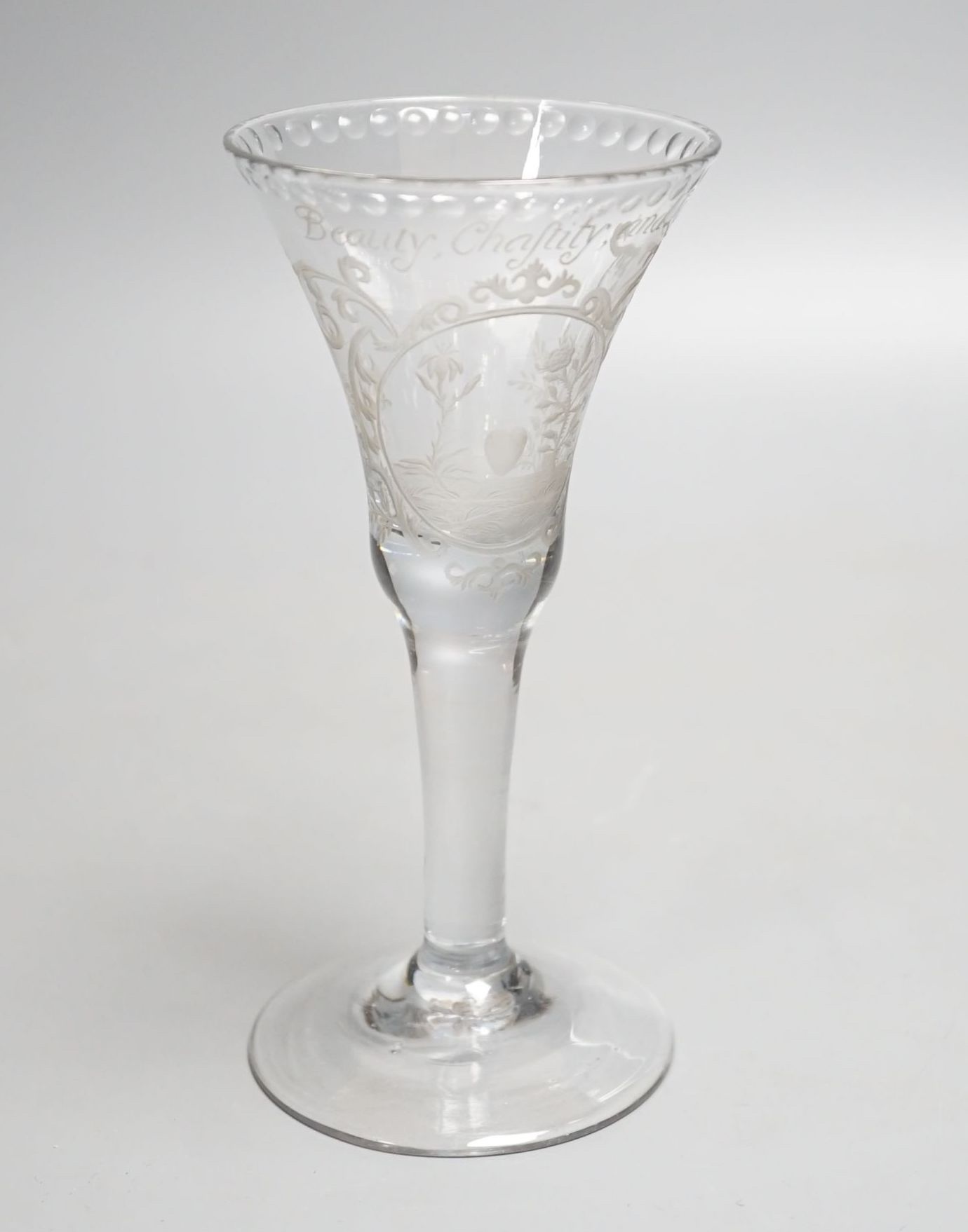 A Georgian wine glass, possibly later engraved ‘Beauty, Chastity, and Love above a lily, heart and rose. 16cm